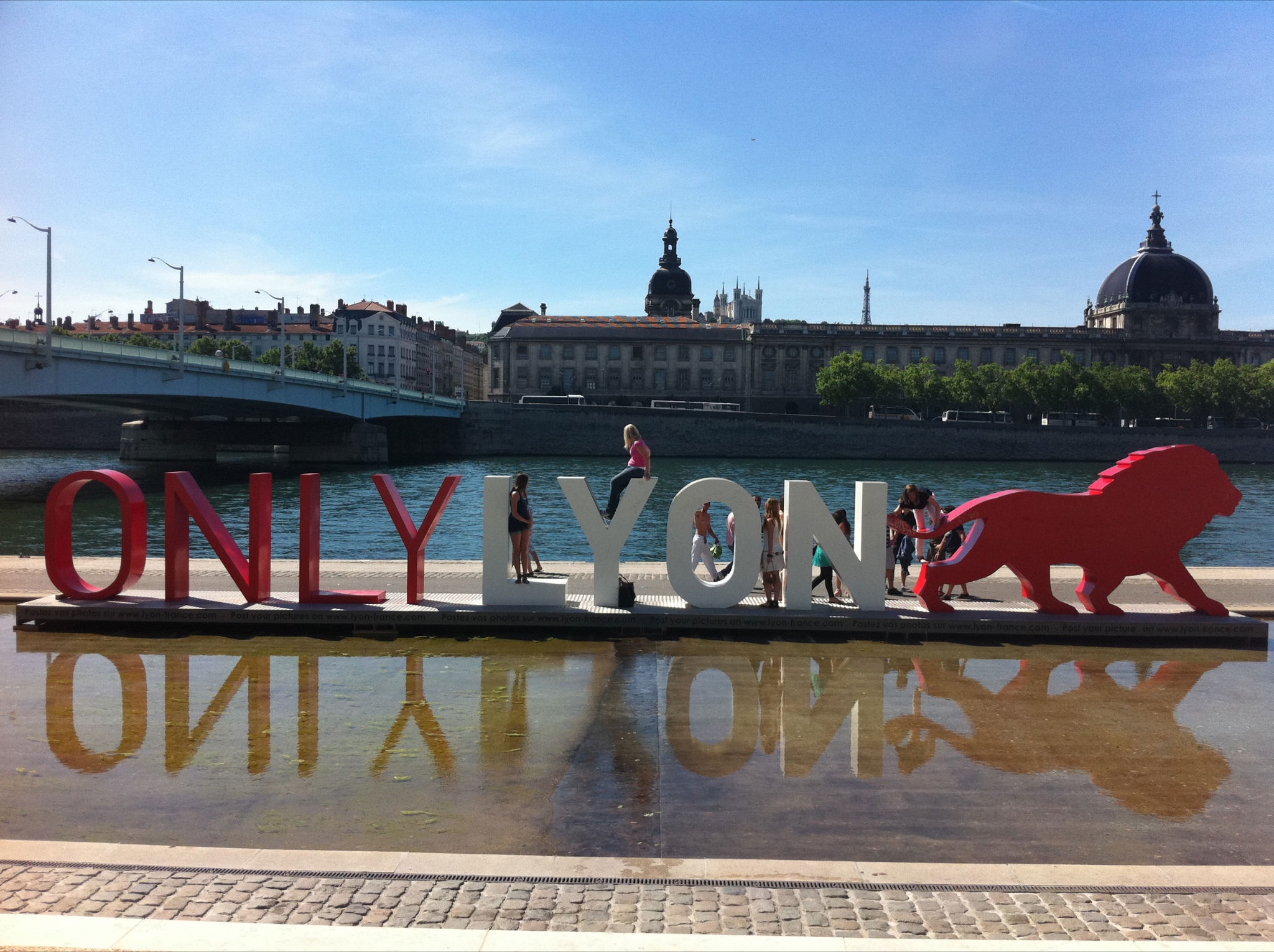 Визуально-текстовый объект «ONLY LYON» на набережной на фоне дворца.